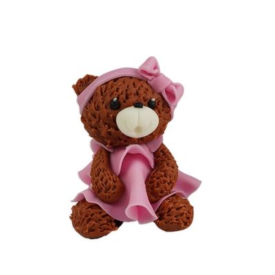 Ein brauner Teddybär mit einem rosa Kleid